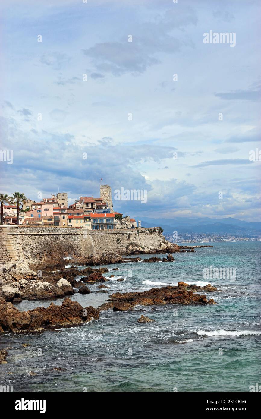 Una vista in lontananza della città costiera di Antibes che mostra la città vecchia, racchiusa da bastioni del 16th ° secolo che si innalzano sopra il mare. Costa Azzurra. Foto Stock