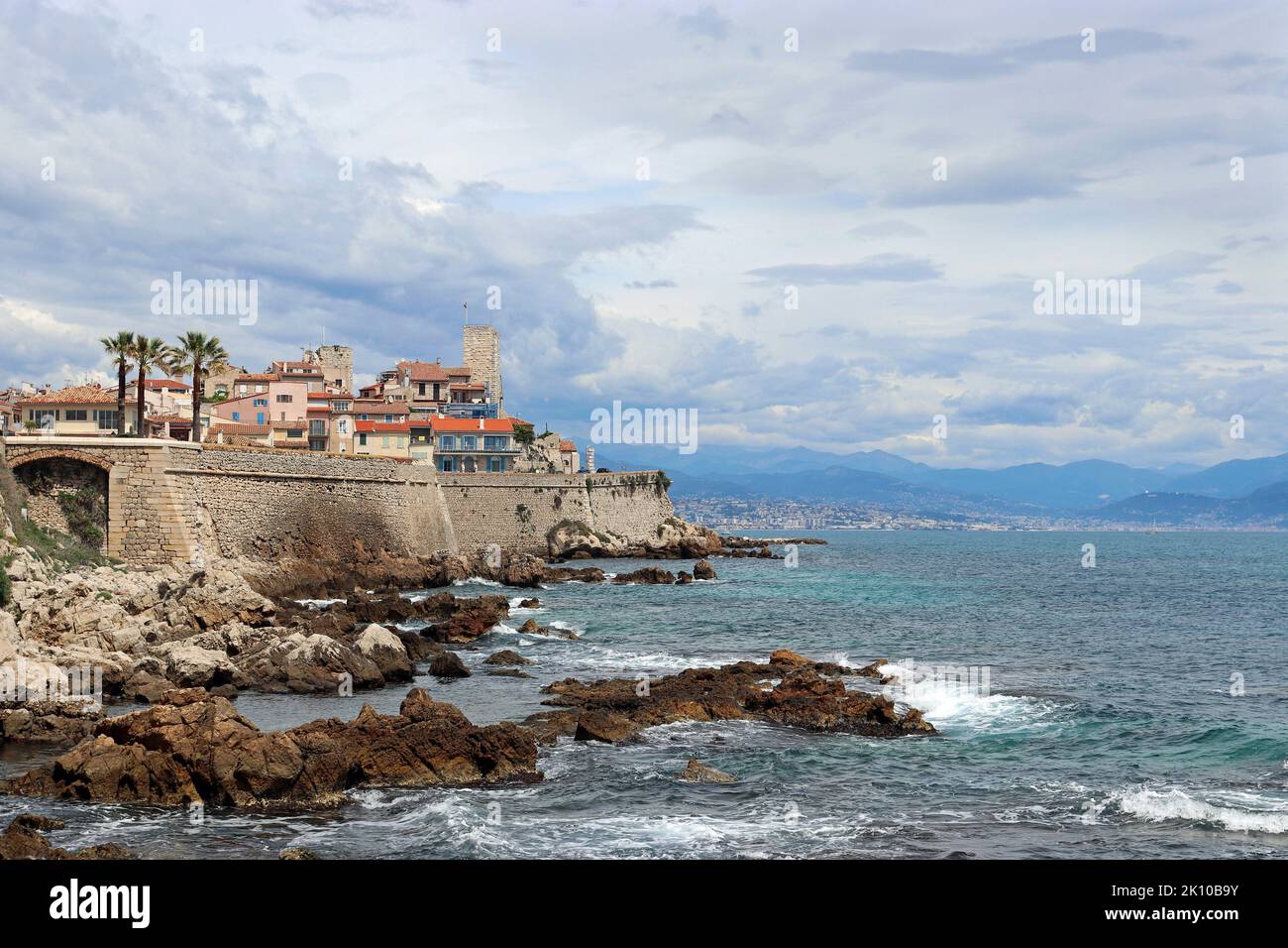 Una vista in lontananza della città costiera di Antibes, mostrando la città vecchia racchiusa da bastioni del 16th ° secolo che si innalzano sopra il mare. Costa Azzurra. Foto Stock