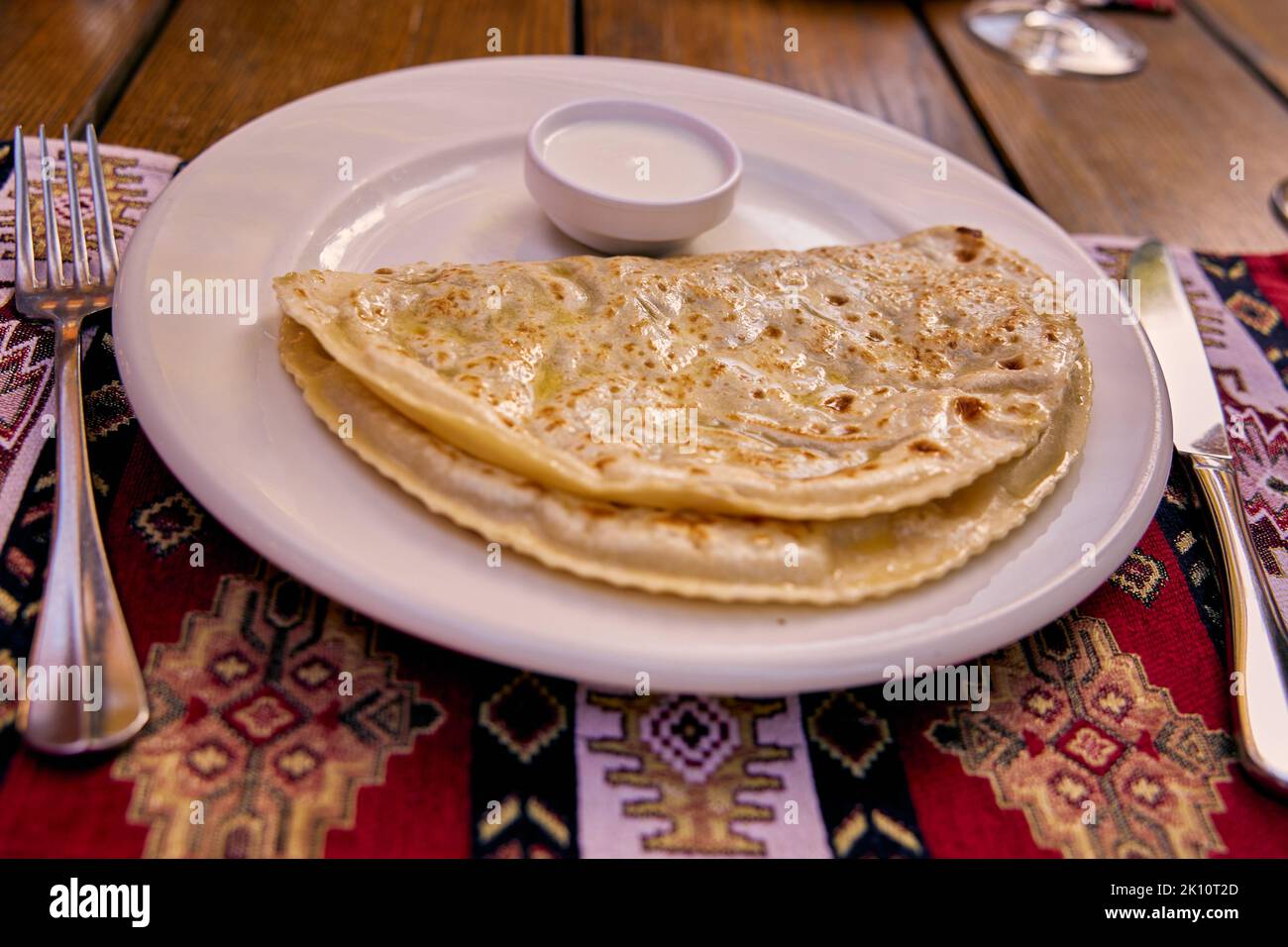 Yantyki con agnello fritto in una padella asciutta e ingrassato con burro con panna acida su un tovagliolo in ceramica, con un tovagliolo sullo sfondo. Crimea Foto Stock