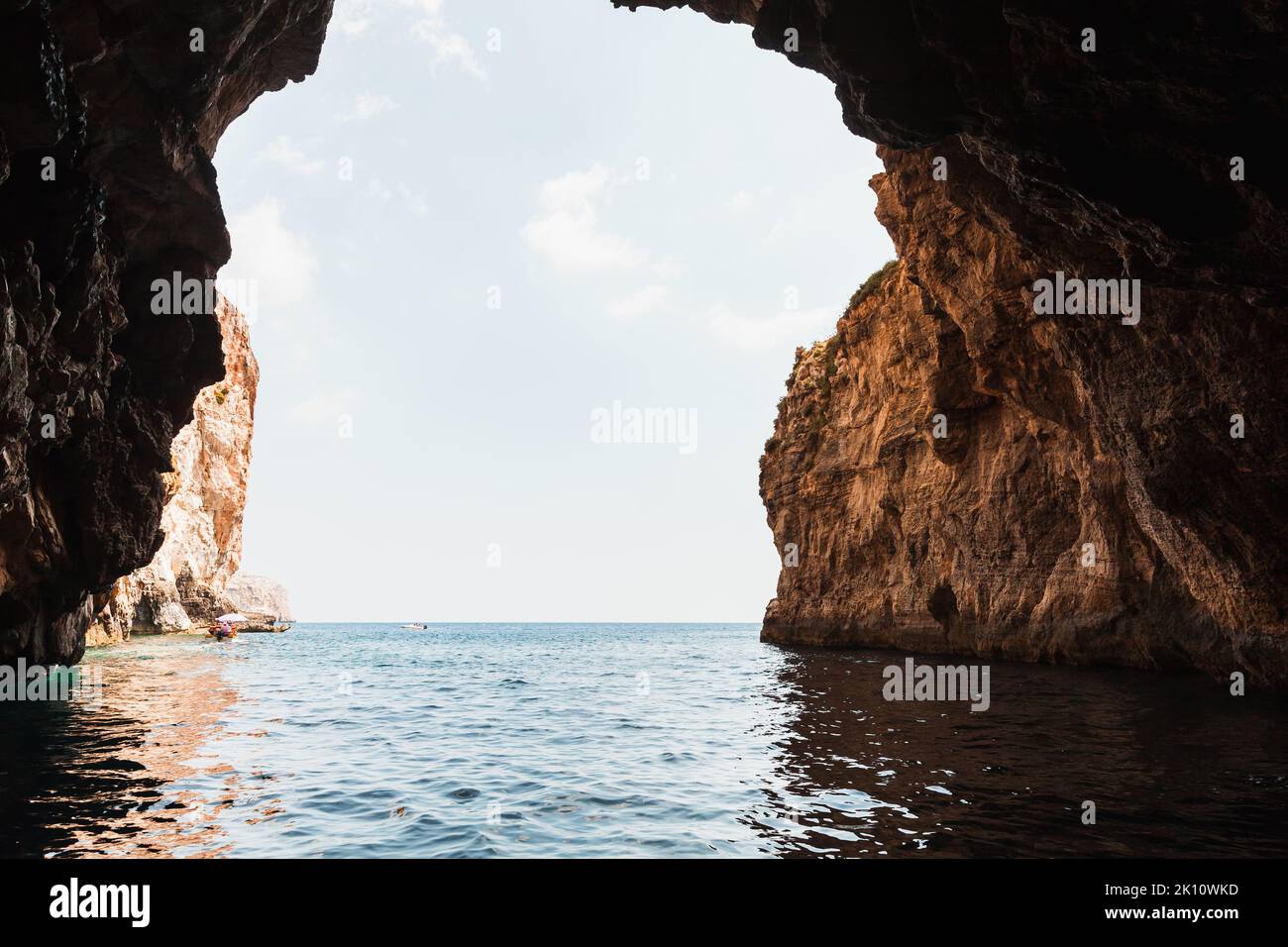 Panorama sul mare con una grotta vuota e scura nella roccia costiera. Grotta Azzurra, Malta Foto Stock