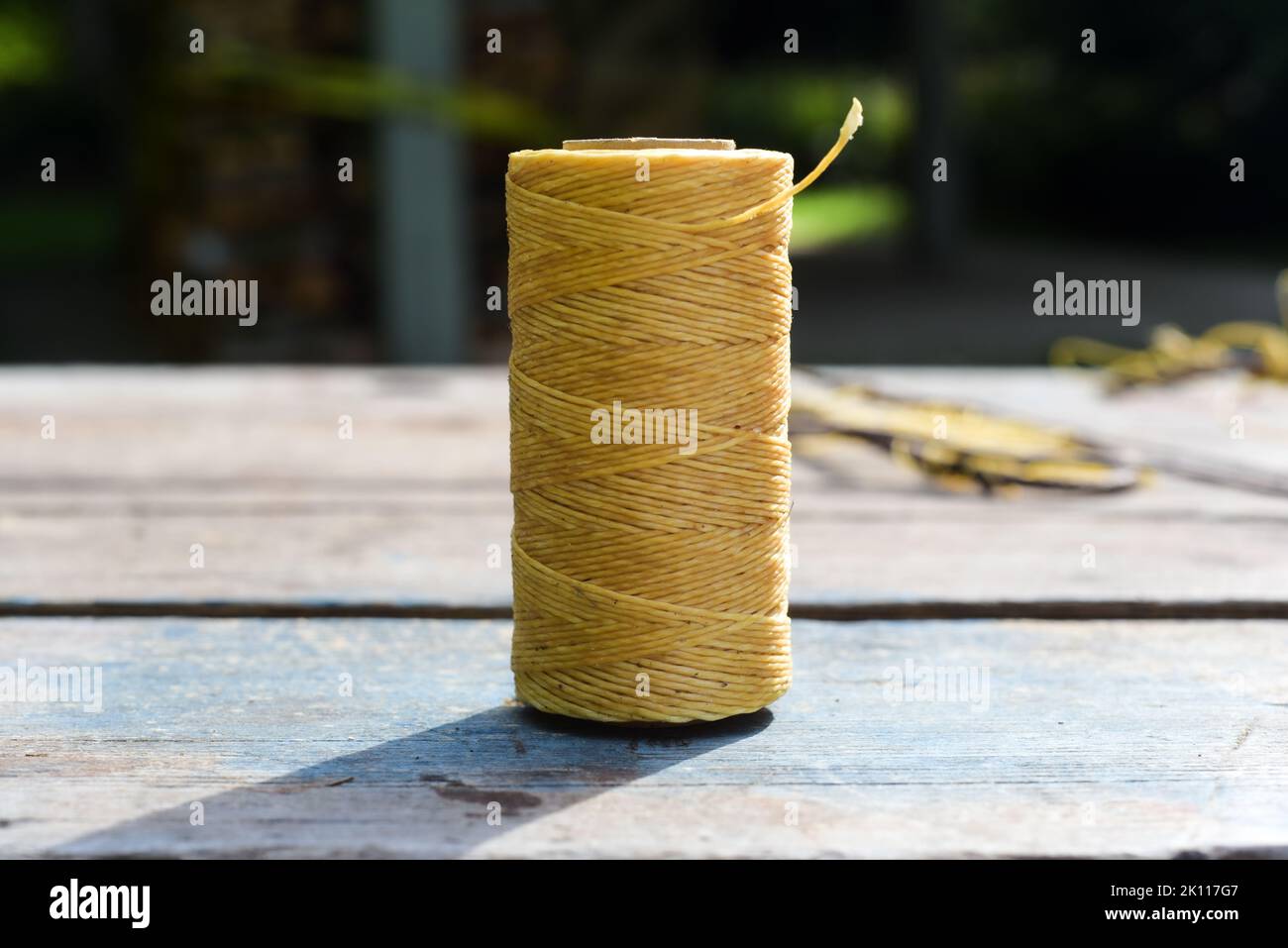 Rocchetto di filo cerato su fondo in legno Foto Stock