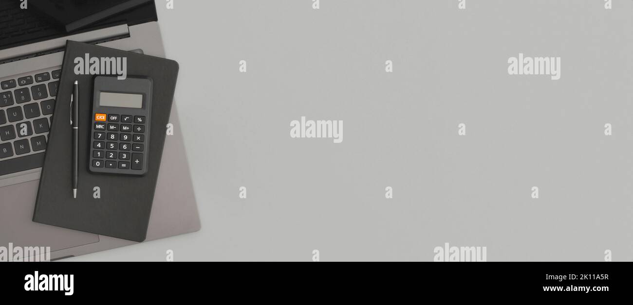 Calcolatrice, notebook, penna su sfondo grigio. Ritorno a scuola Foto Stock