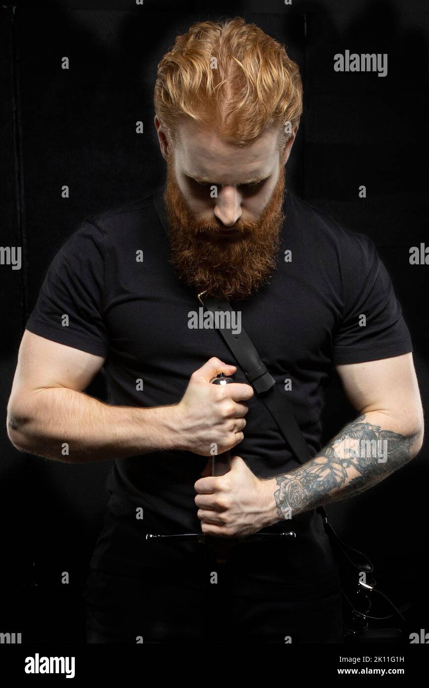 Un uomo fantasy urbano con capelli rossi e barba sullo sfondo di uno studio nero Foto Stock