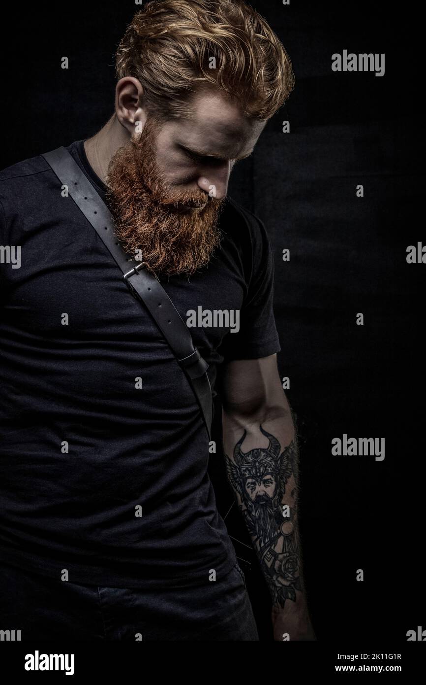 Un uomo fantasy urbano con capelli rossi e barba sullo sfondo di uno studio nero Foto Stock