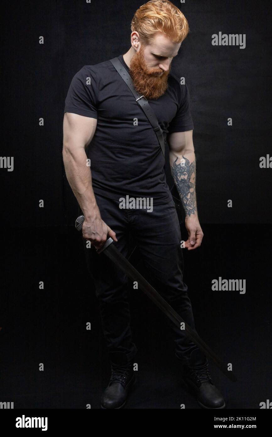 Un uomo fantasy urbano con capelli rossi e barba sullo sfondo di uno studio nero Foto Stock