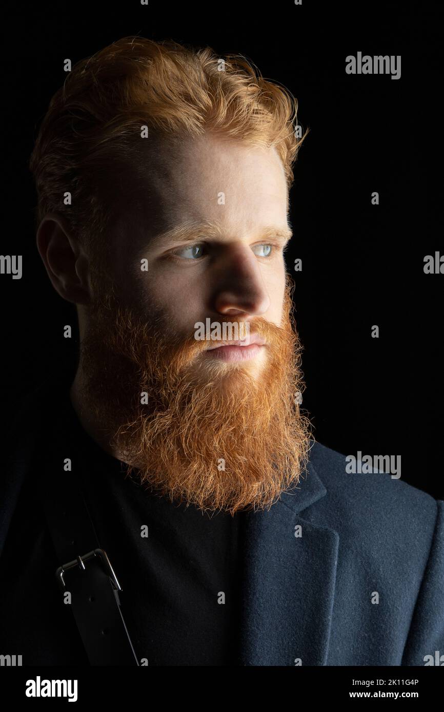 Un uomo fantasy urbano con capelli rossi e barba sullo sfondo di uno studio nero Foto Stock