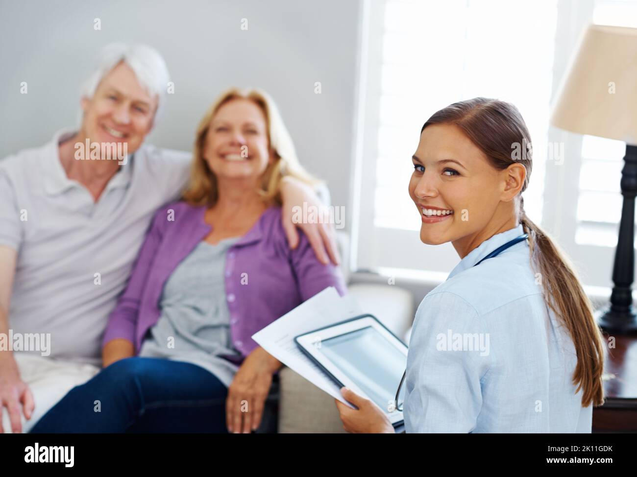 Affrontiamo tutti gli ostacoli insieme. Ritratto di una coppia anziana seduta con una giovane infermiera. Foto Stock