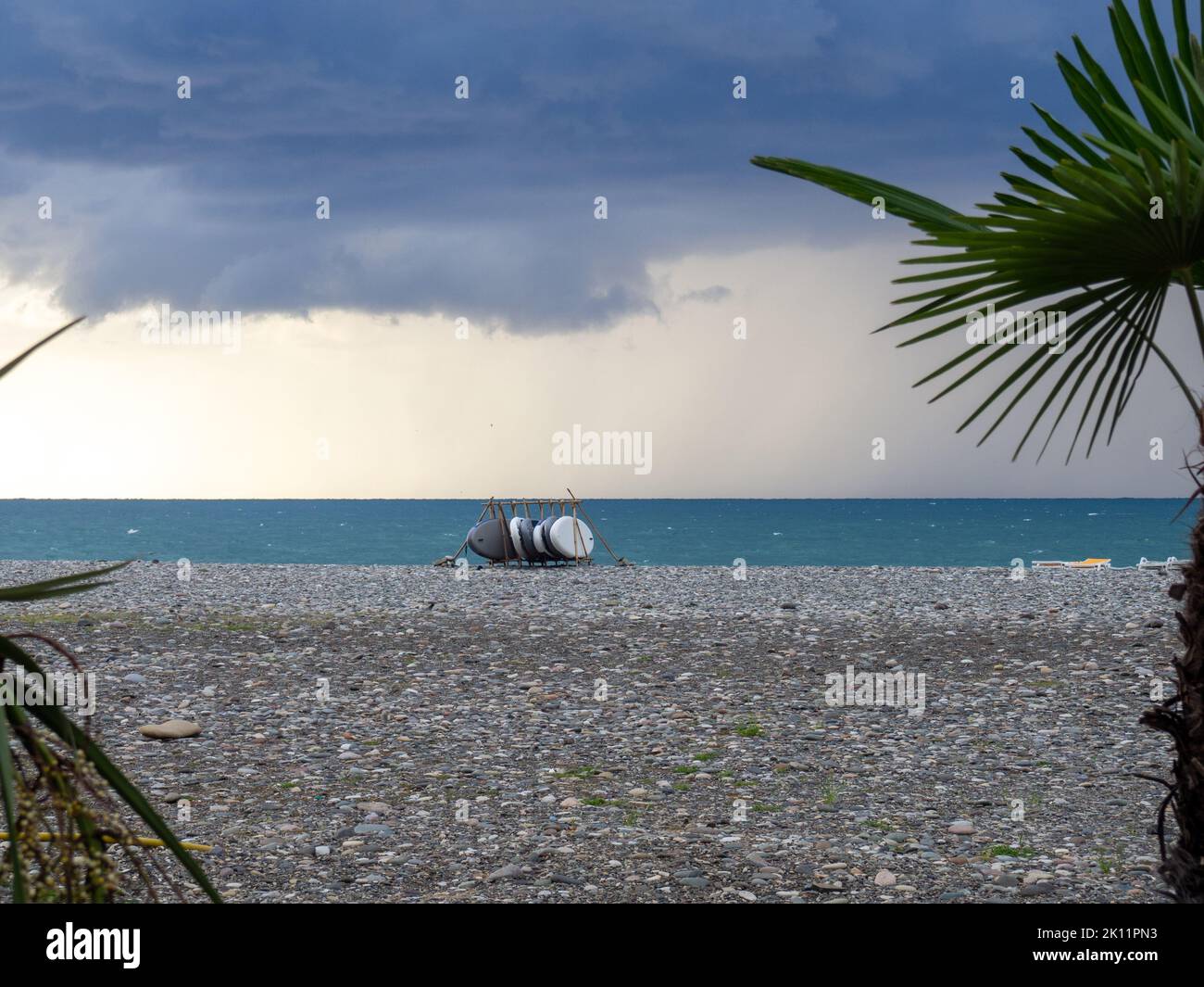 Tavole da windsurf piegate. Fine della stagione balneare. Non è il tempo di fare il bagno. Onda alta. Non c'è gente sulla spiaggia Foto Stock