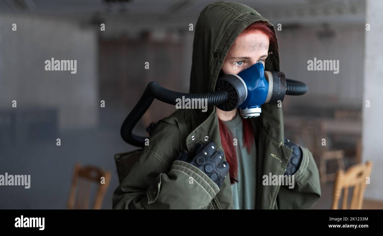 Concetto post apocalittico. Donna in maschera a gas in edificio abbandonato. Foto Stock