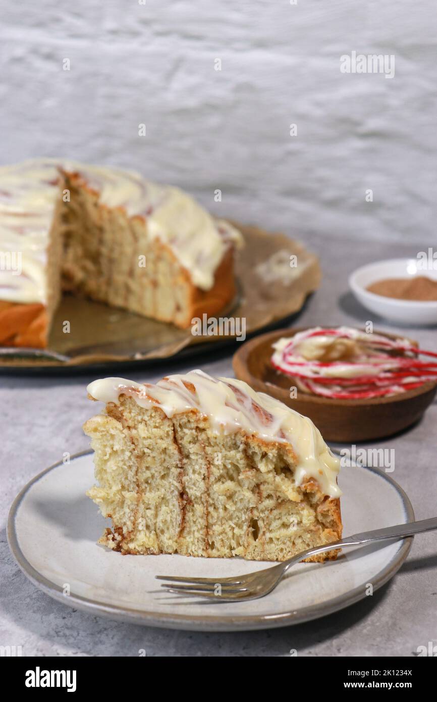 primo piano di un rotolo di cannella gigante, sfondo bianco con spazio copia, tavolo in marmo grigio Foto Stock