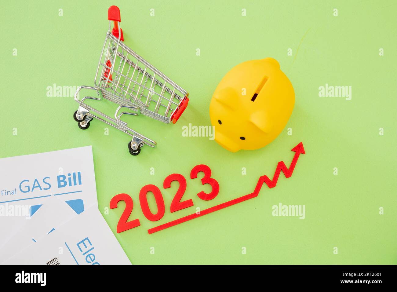 2023 anno, costo della vita, generi alimentari e prezzi alimentari in aumento, risparmio. Carrello della spesa piggy bank e freccia rossa in alto. Foto Stock