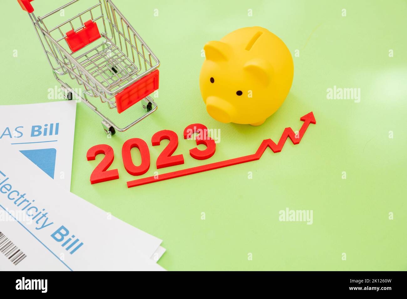 2023 anno, costo della vita, generi alimentari e prezzi alimentari in aumento, risparmio. Carrello della spesa piggy bank e freccia rossa in alto. Foto Stock
