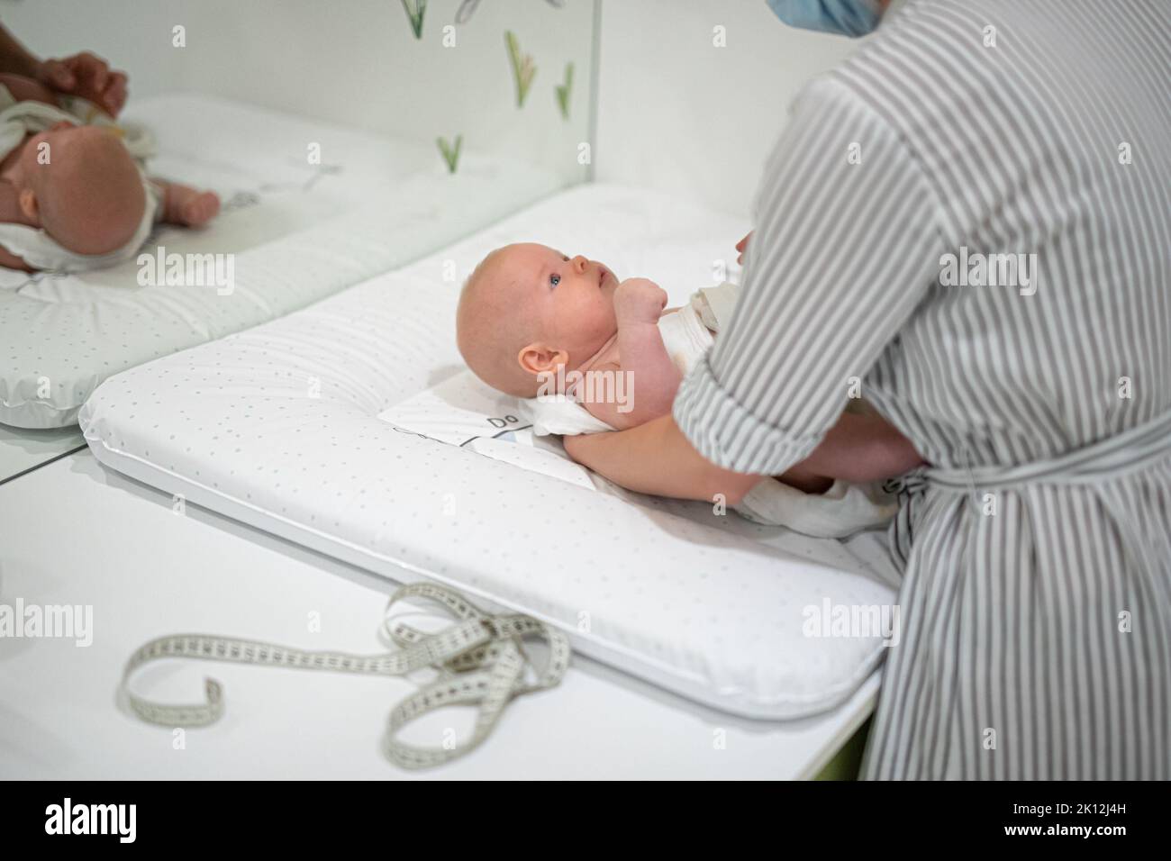 Bambino disteso sulla schiena che viene messured durante un controllo medico standard. Foto Stock