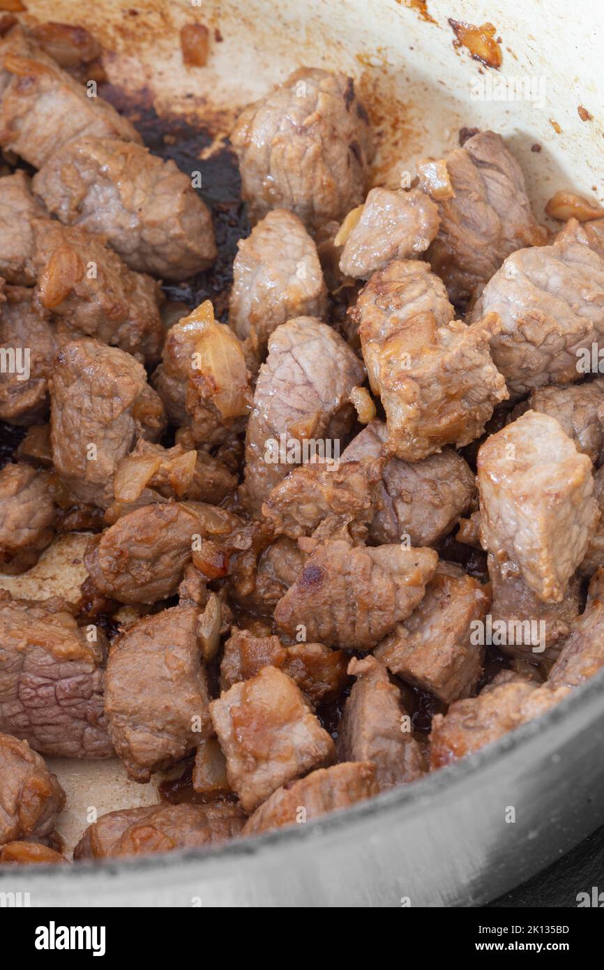 Manzo a dadini con cipolle, manzo Aberdeen Angus, cottura in una casseruola di ceramica Foto Stock