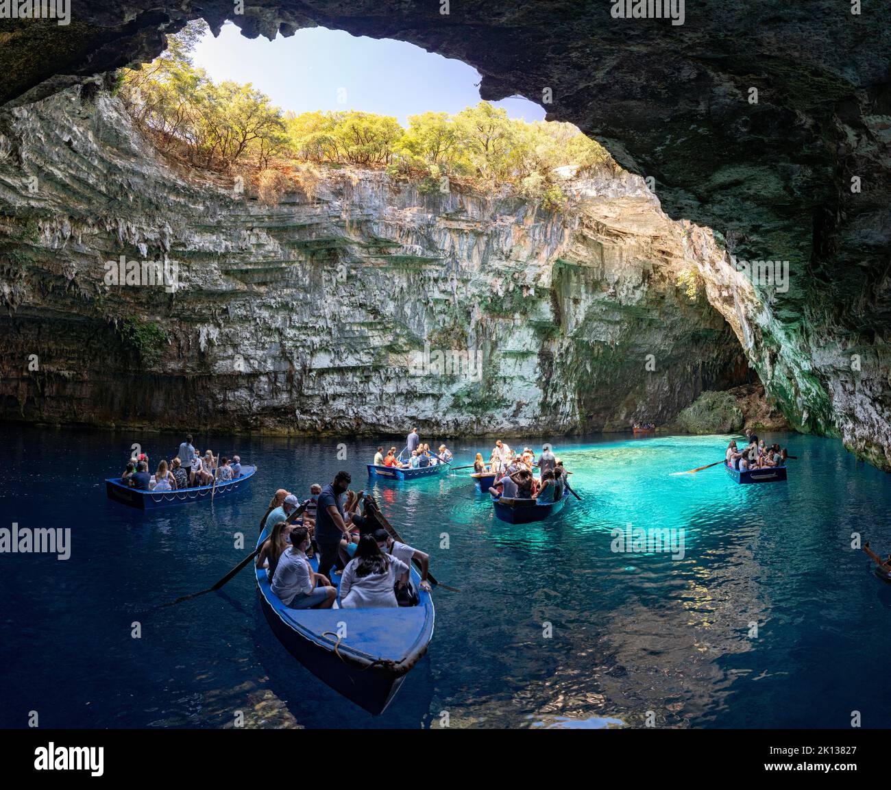 Barche turistiche nelle acque cristalline blu della grotta del lago Melissani, Cefalonia, Isole IONIE, Isole greche, Grecia, Europa Foto Stock