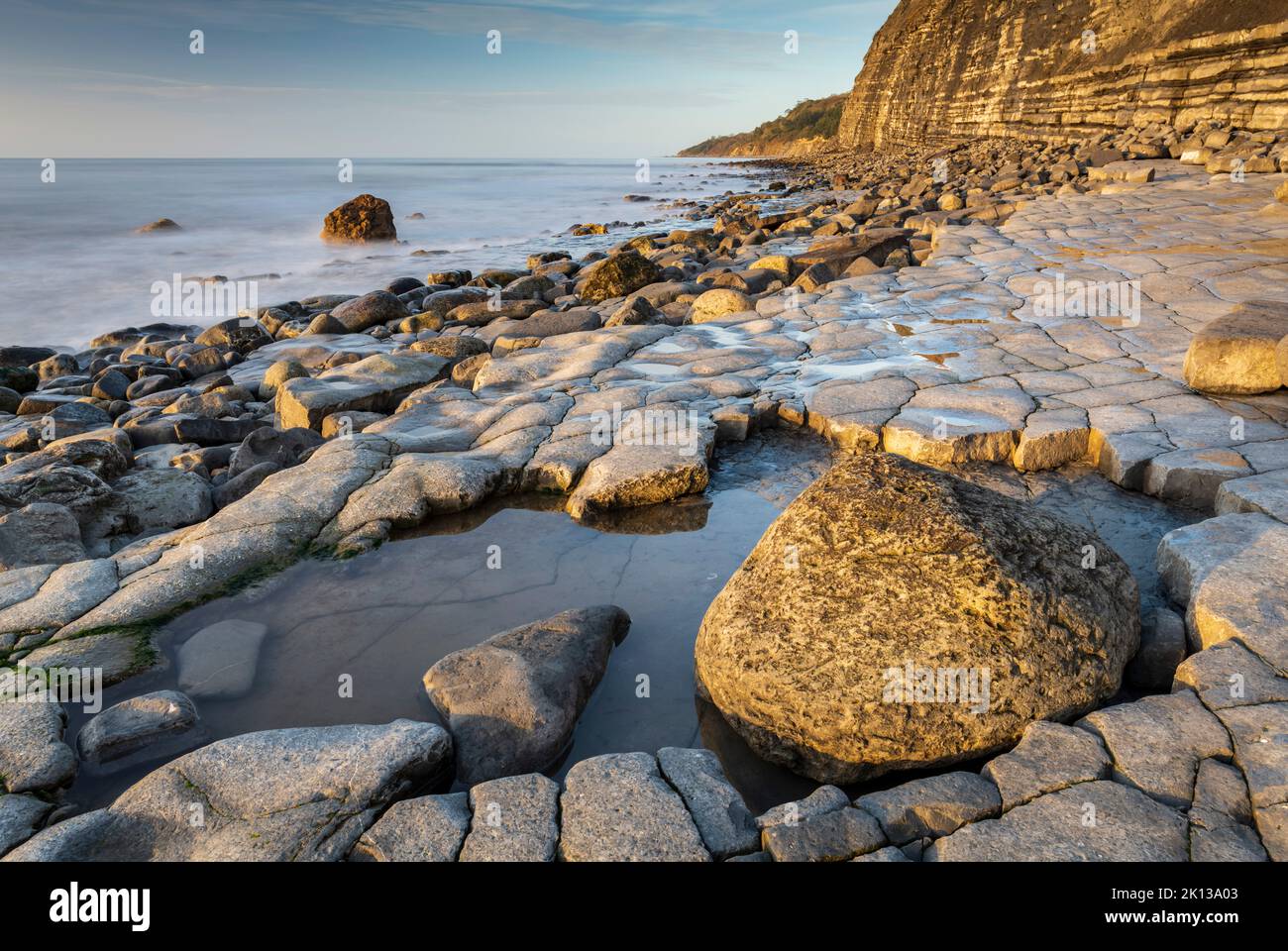 Luce del sole mattutina sul marciapiede Ammonite vicino a Lyme Regis, Dorset, Inghilterra, Regno Unito, Europa Foto Stock