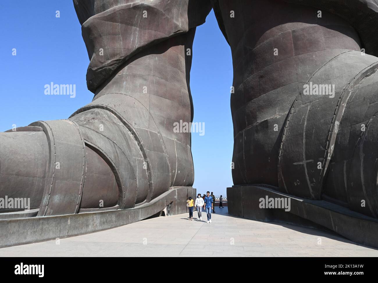 Visitatori tra i piedi della Statua dell'unità, la statua più alta del mondo a 182m km di Vallabhbhai Patel, Kevadia, Gujarat, India, Asia Foto Stock