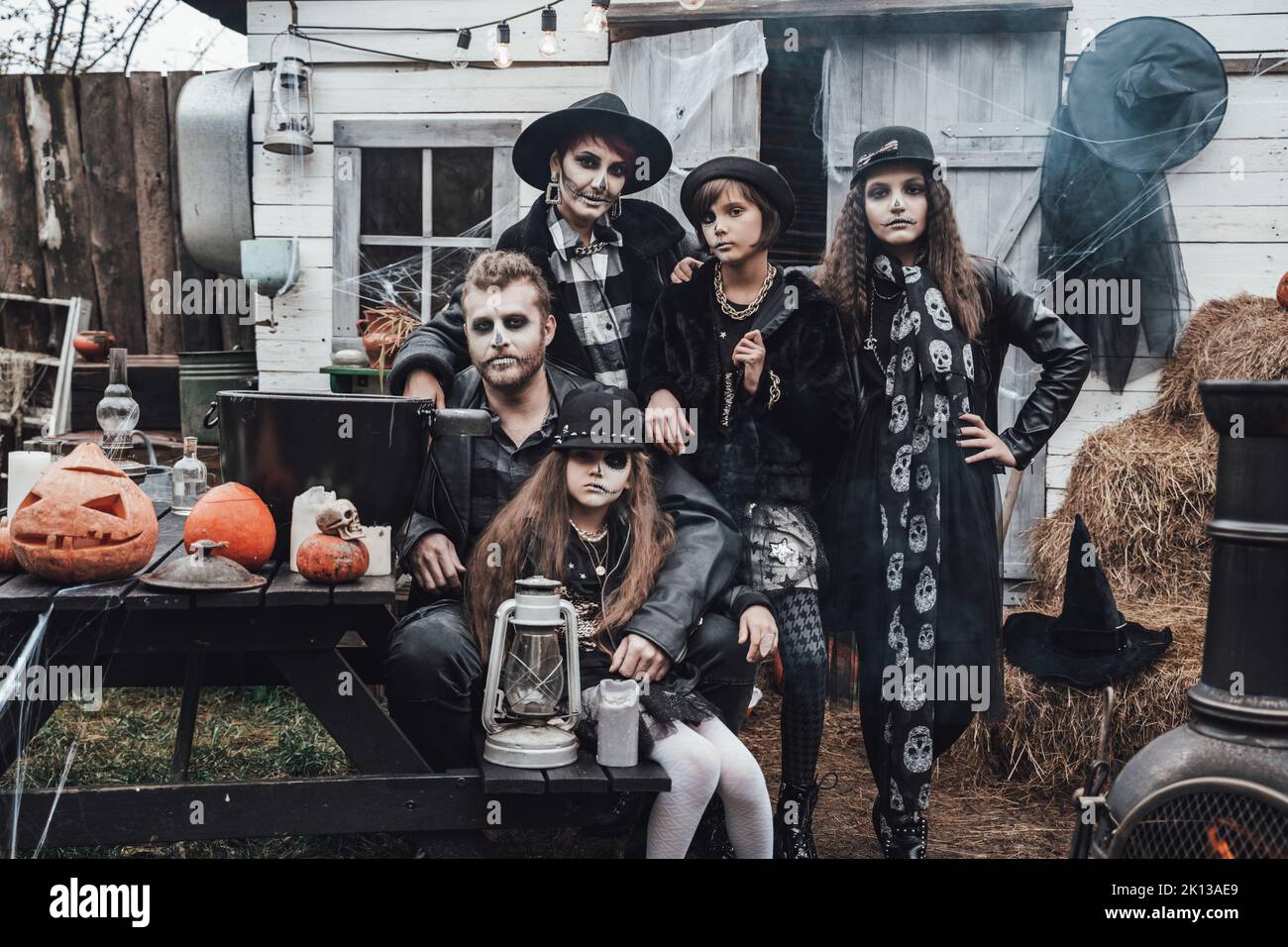 Famiglia spaventosa, madre, padre, figlie che celebrano Halloween. Terrificante cranio nero mezza faccia trucco e costumi strega, elegante images.Horror, divertimento a Foto Stock