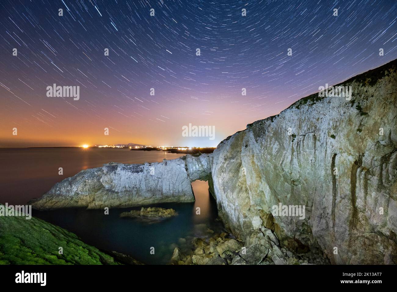 Star trail e cielo notturno su BWA Gwyn o l'Arco Bianco, vicino a Rhoscolyn, Anglesey, Galles del Nord, Regno Unito, Europa Foto Stock