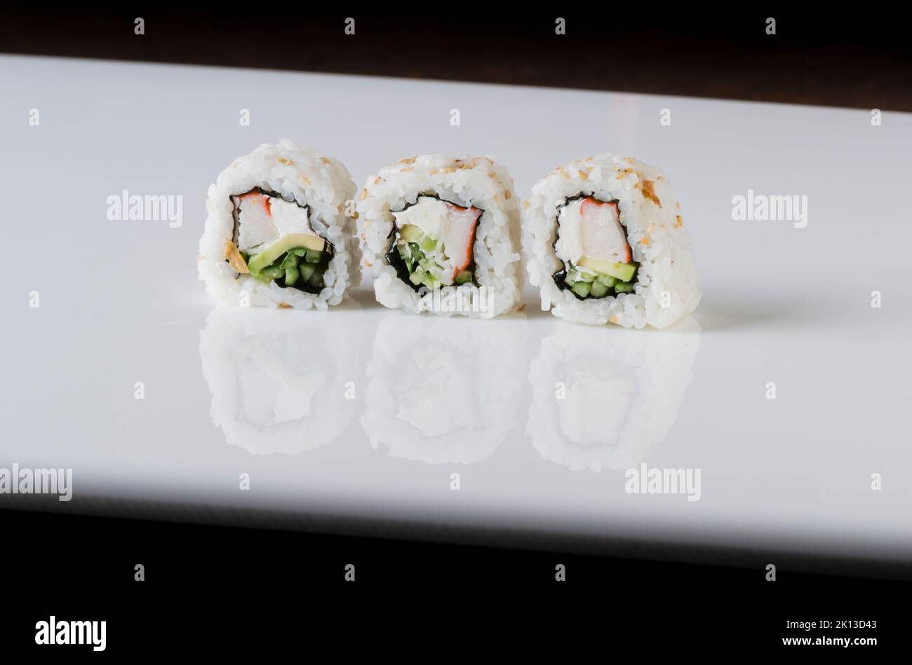 Un primo piano laterale di sushi rotoli isolato su sfondo bianco con linee nere Foto Stock
