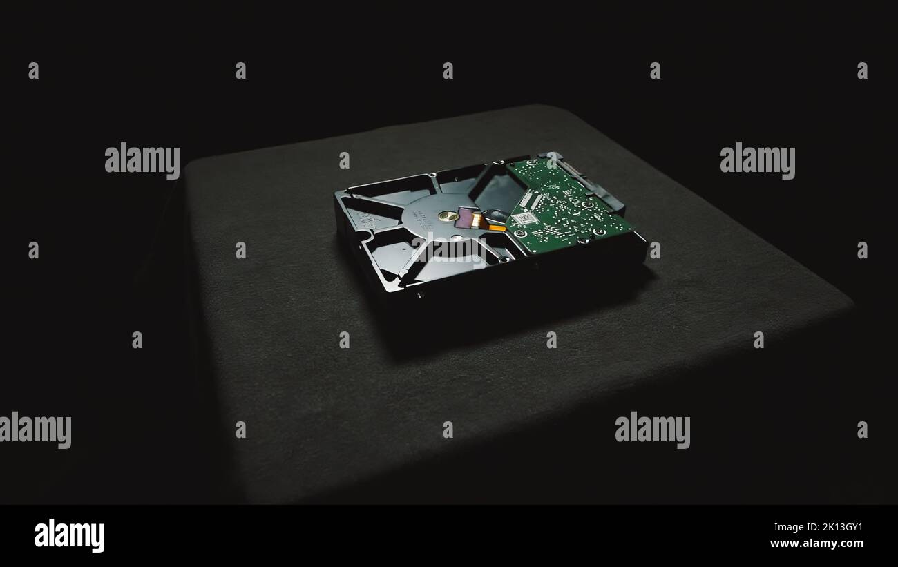 La parte inferiore di un'unità disco rigido in una stanza buia sulla superficie tessile. Foto Stock