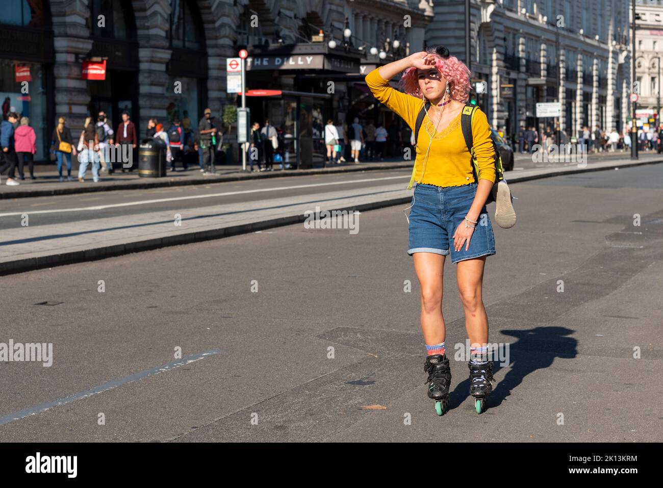 Giovane donna su lame a rullo, pattinaggio su Piccadilly a Londra, Regno Unito. Strade vuote durante il periodo di lutto per la Regina e chiusure stradali Foto Stock