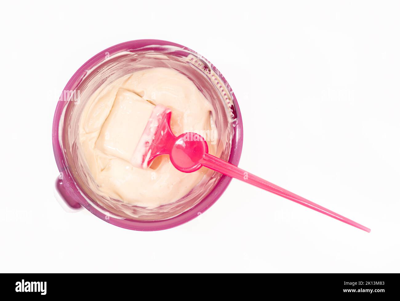 Vista dall'alto di una ciotola con tintura per capelli e spazzola isolata su sfondo bianco. Colorazione dei capelli Foto Stock