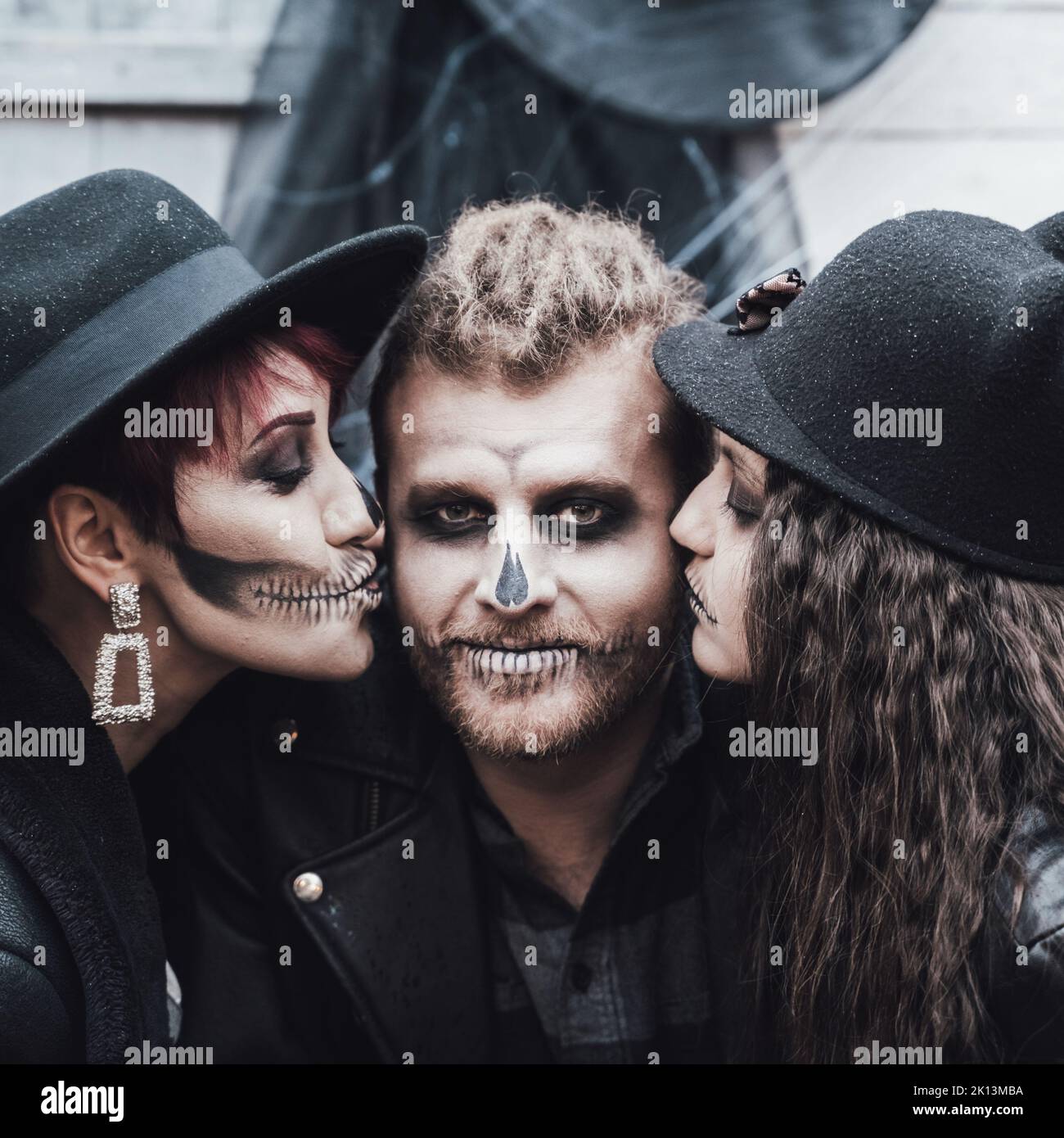 Famiglia spaventosa, madre, padre, figlie che celebrano Halloween. Terrificante cranio nero mezza faccia trucco e costumi strega, elegante images.Horror, divertimento a Foto Stock