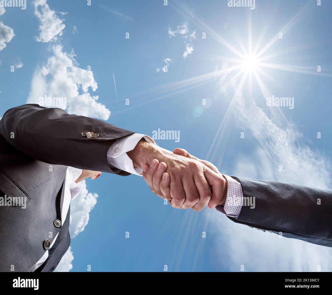 Concetto di partenariato economico o politico. Primo piano stretta di mano contro un cielo blu soleggiato. Concetto di pace. Foto Stock