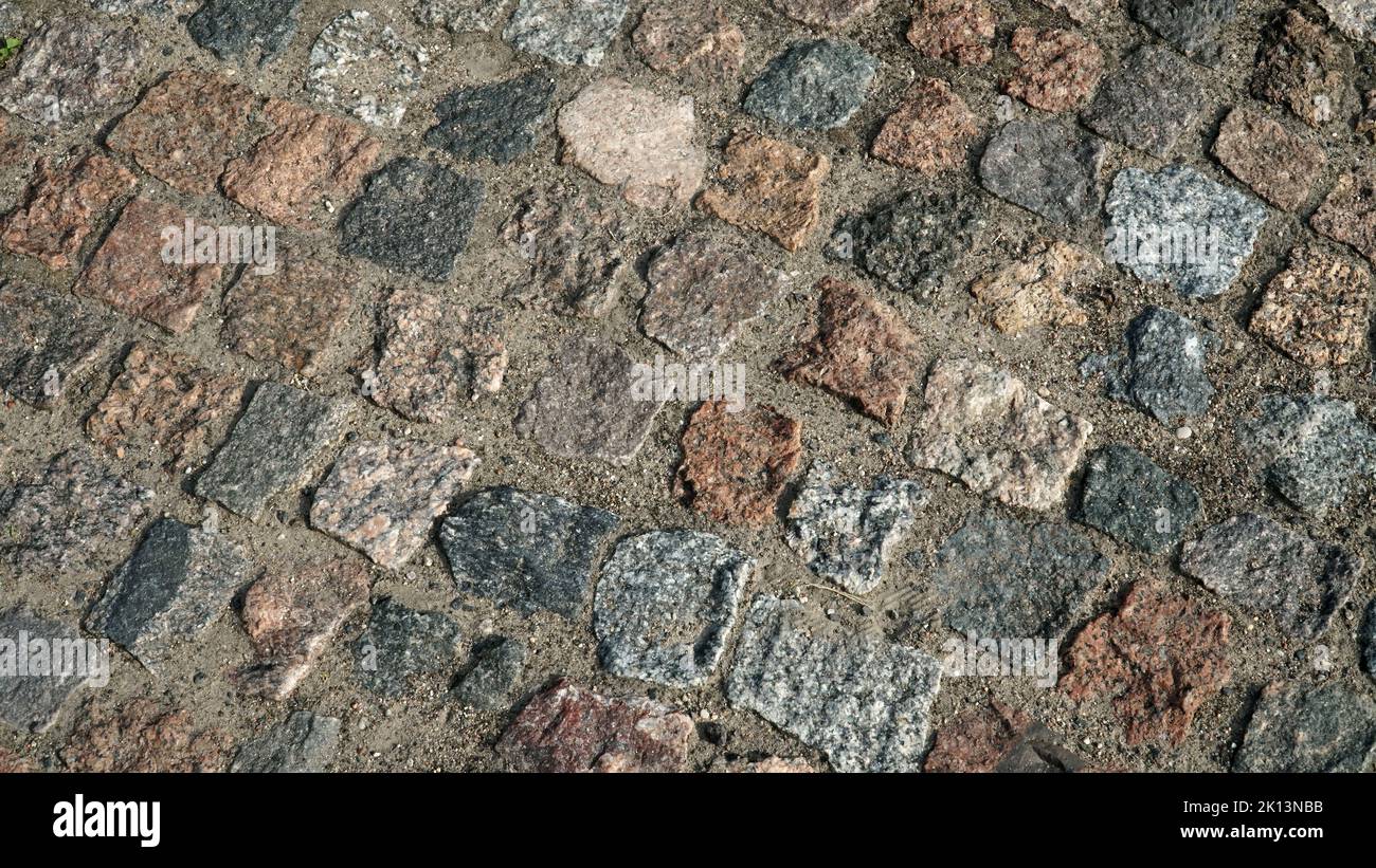 Il ciottolato. Sfondo con pavimentazione in pietra decorativa colorata, che imita la strada storica in un ambiente urbano o superficie quadrata cittadina i Foto Stock