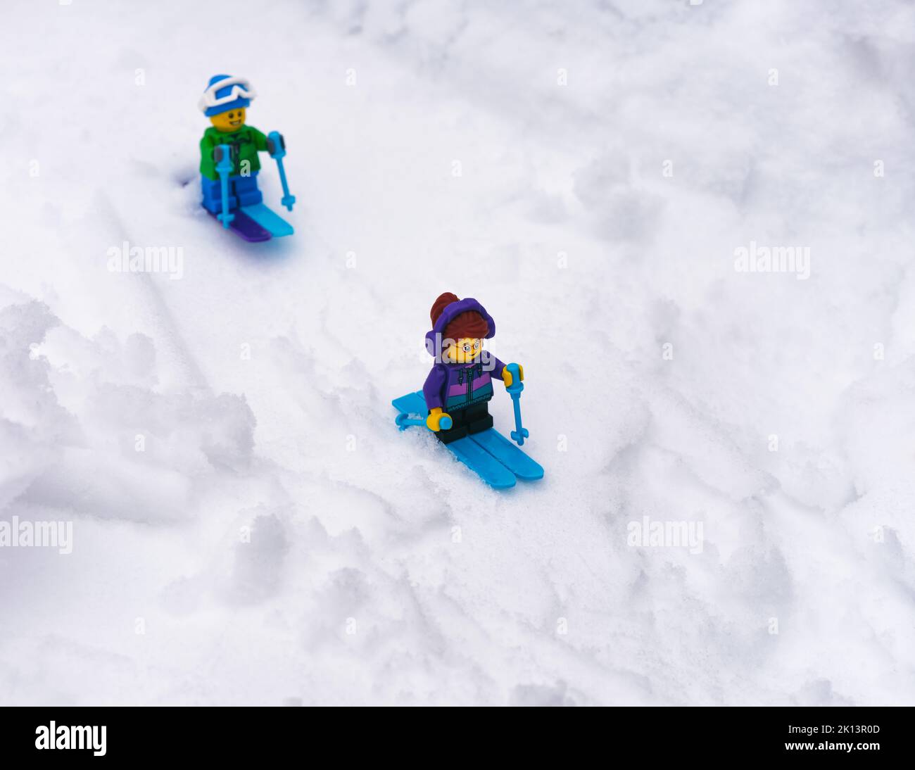 Tambov, Federazione Russa - 18 gennaio 2022 le minifigure di Lego ragazza e ragazzo sciano giù una collina innevata Foto Stock