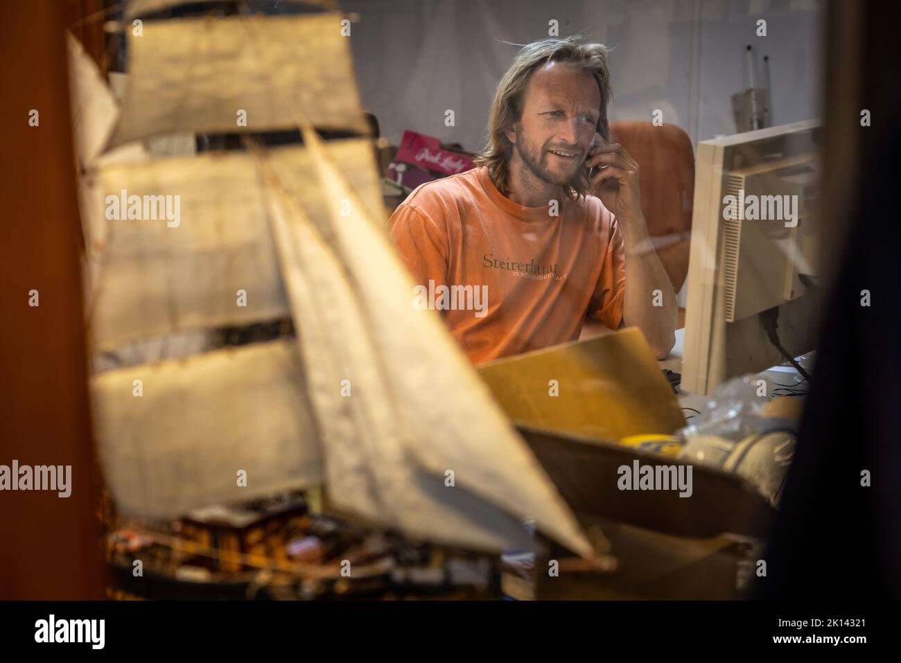 Il capitano Andreas Lackner, fondatore della compagnia di navigazione 'Fairtransport', qui nel suo ufficio nel porto di Den Helder nei Paesi Bassi. Qui viene preparato dall'equipaggio per il suo prossimo viaggio. La goletta 'Tres Hombres' trasporta merci come vino, caffè, cioccolato e rum dai Caraibi attraverso l'Atlantico all'Europa in un modo completamente neutro dal clima. Foto Stock