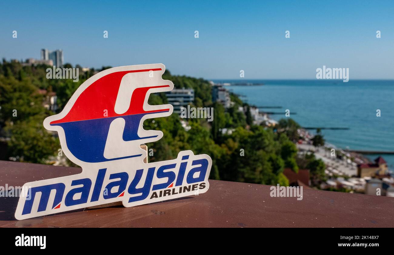 Agosto 26, Sochi, Russia. L'emblema della compagnia aerea malese Malaysia Airlines sullo sfondo del terrapieno e del litorale del resort TOW Foto Stock