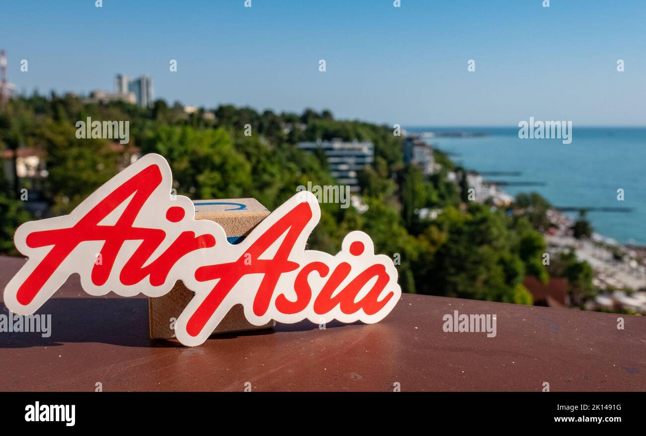 Agosto 26, Sochi, Russia. L'emblema della compagnia aerea malese AirAsia sullo sfondo del terrapieno e della riva del mare nella città del resort. Foto Stock