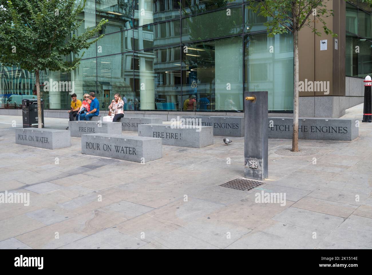 Sedili in pietra di granito con parole scolpite da Londons Burning, una canzone per bambini sul grande fuoco di Londra. Monument Square, Londra, Inghilterra, Regno Unito Foto Stock