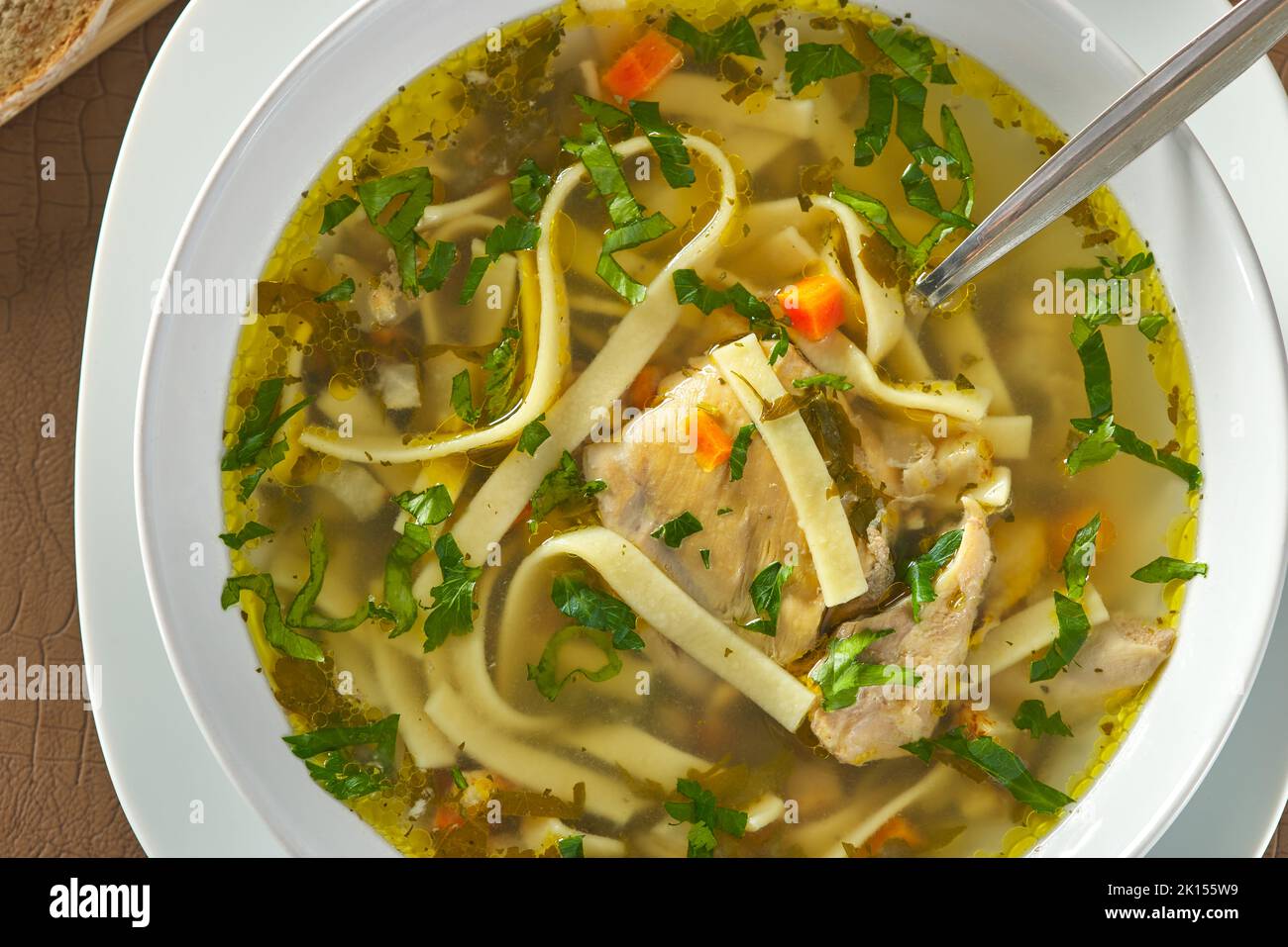 Zuppa di spaghetti di pollo con prezzemolo e verdure in un piatto bianco - vista dall'alto Foto Stock