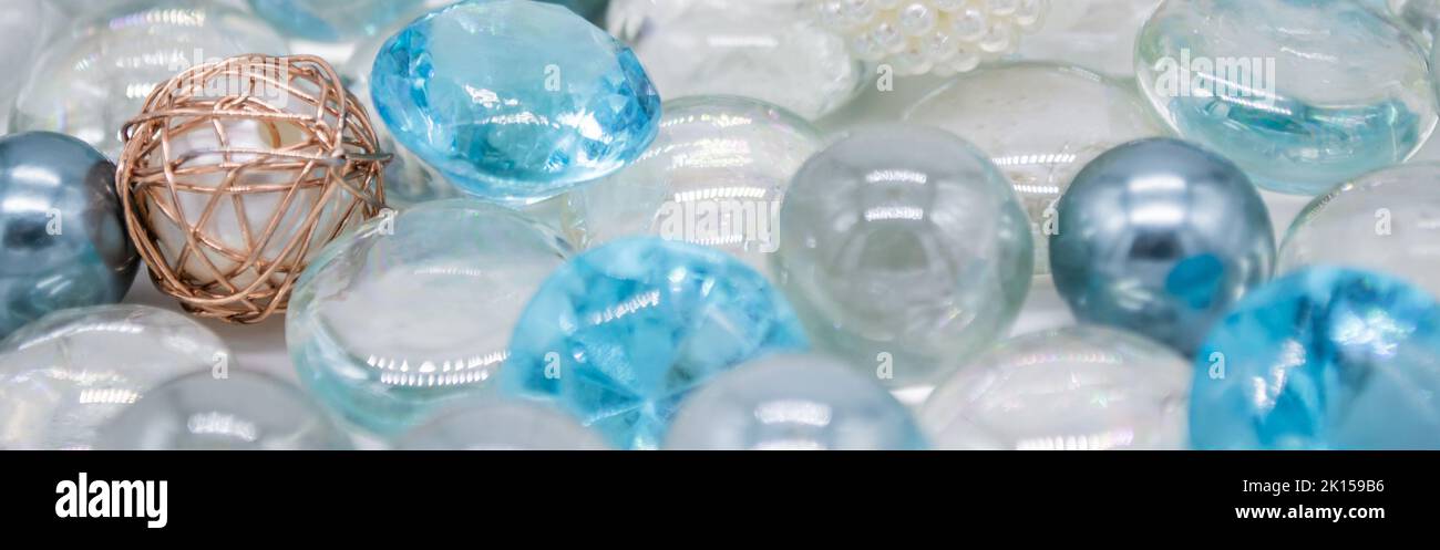Banner con bellissimo sfondo trasparente, perle di vetro blu, cristalli, perle bianche. Spazio di copia. Foto Stock