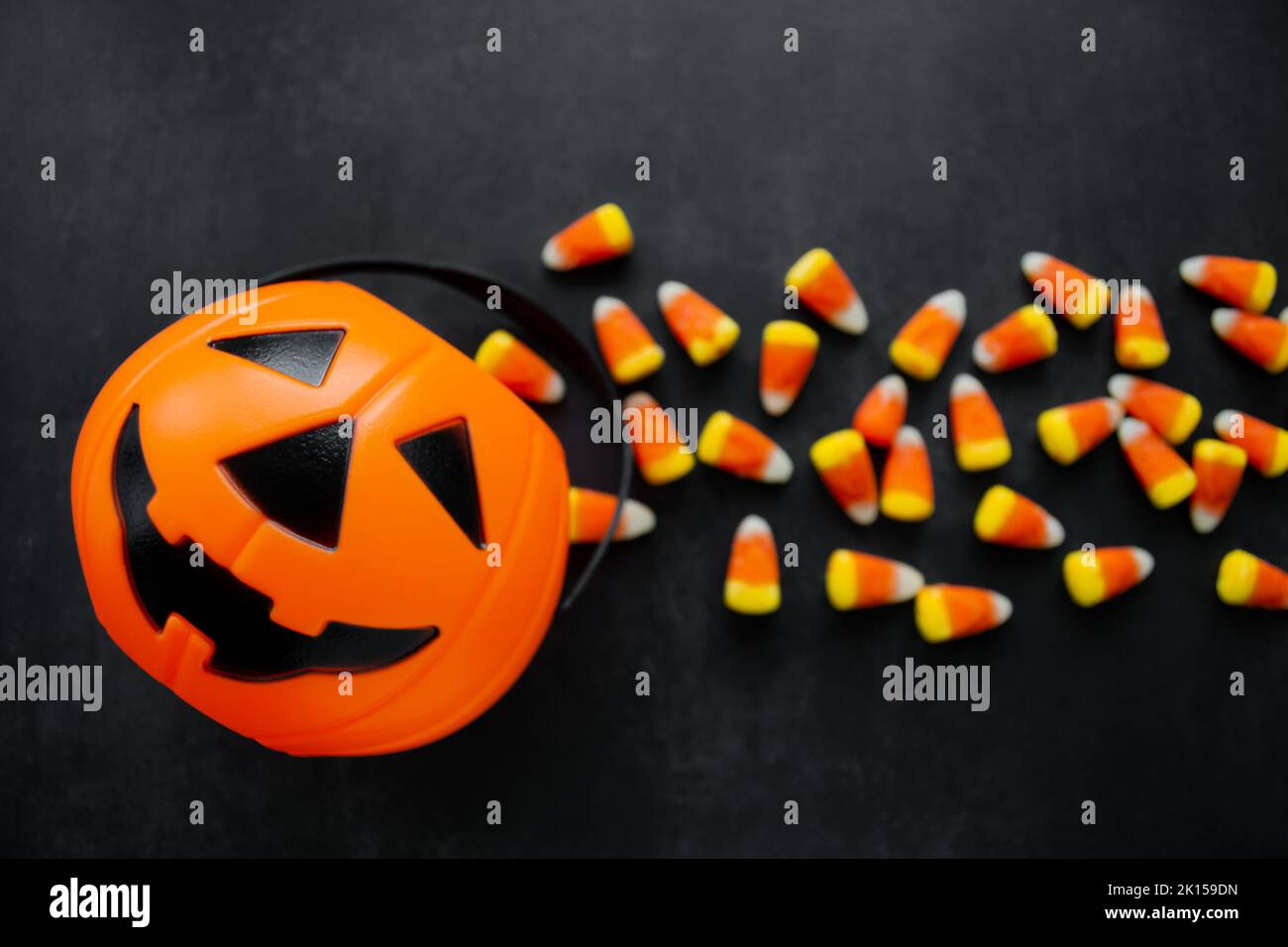 Halloween sfondo caramelle di mais caramelle, cestino di zucca. Dolci tradizionali. Spazio di copia. Foto Stock