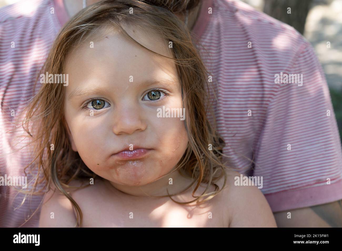 Ritratto di un bambino carino. Il bambino mangia un cocomero e guarda la macchina fotografica . Stile di vita. Candida. Il concetto di una vacanza attiva in famiglia. Vista frontale. Primo piano. Foto Stock