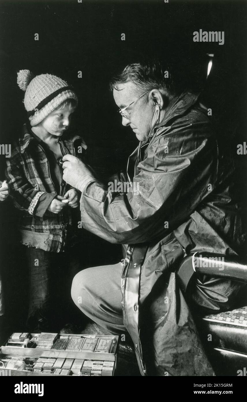 Il medico di paese Gaine Cannon tratta un bambino durante un housecall. Foto Stock