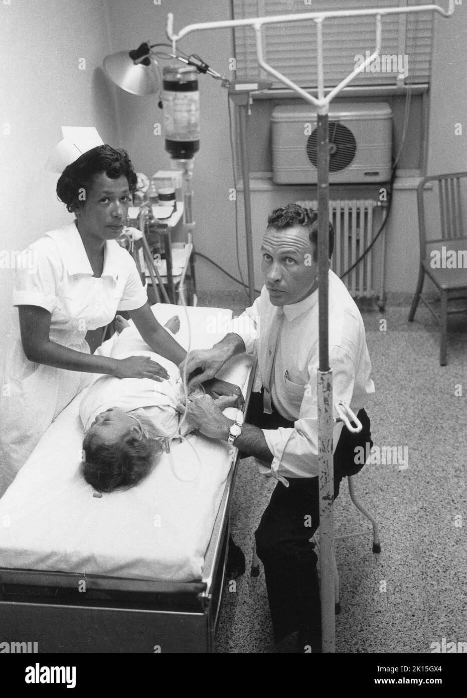 Nel 1961, il Dr. Lloyd McGaskill tratta un bambino gravemente disidratato nel pronto soccorso di un piccolo ospedale rurale a Laurinburg, NC. Foto Stock