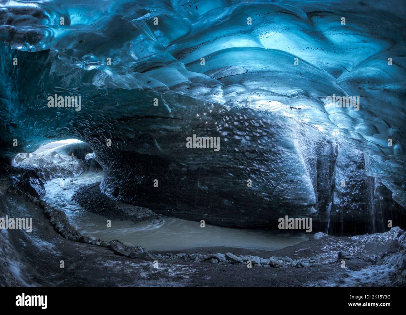 Grotta di ghiaccio Skaftadell con pareti blu ruvide e ruscello nella fredda giornata invernale in Islanda Foto Stock