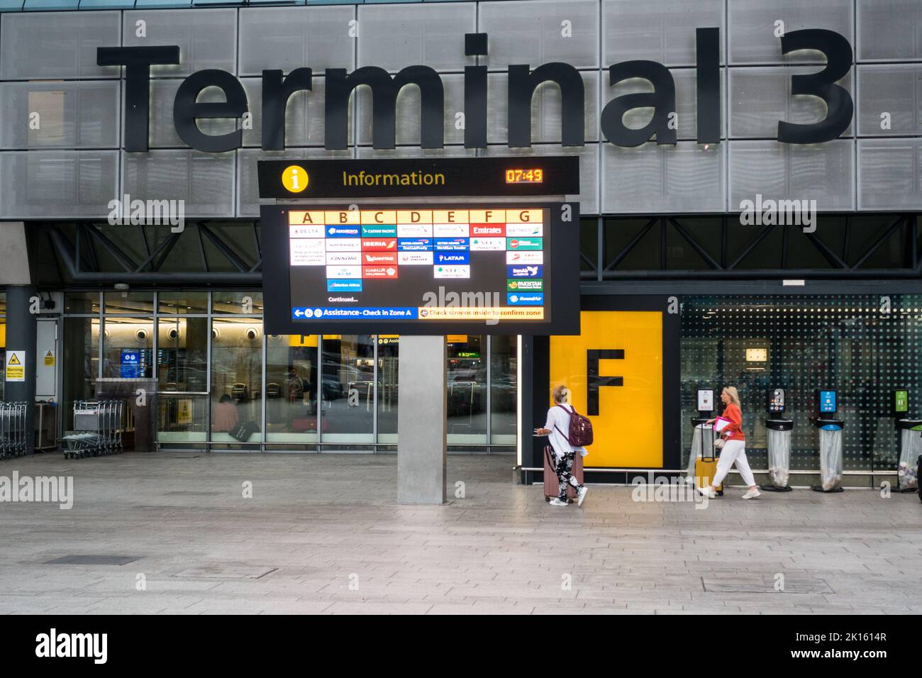 I viaggiatori che entrano nell'edificio del Terminal 3 di Heathrow Foto Stock