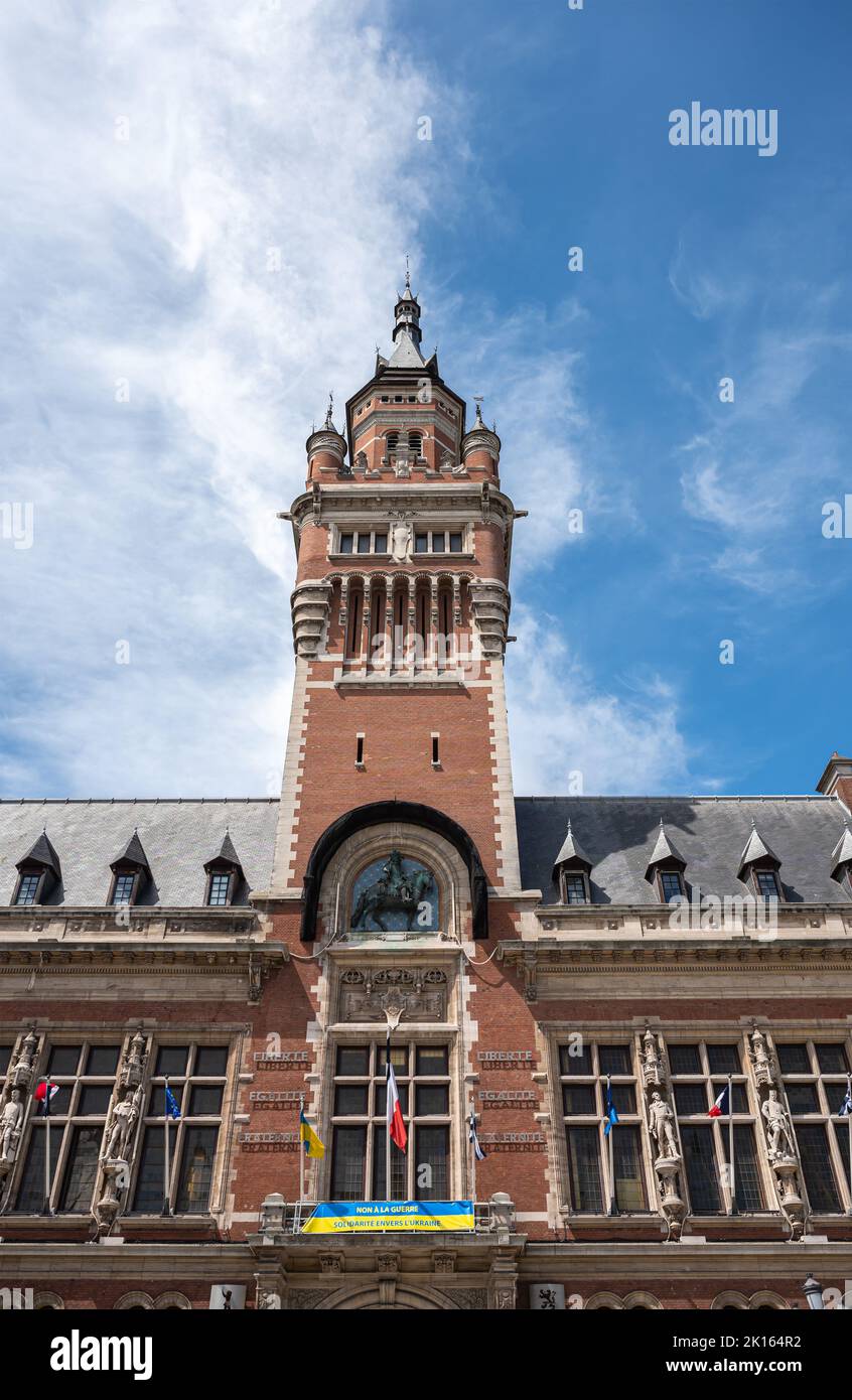 Europa, Francia, Dunkerque - 9 luglio 2022: Primo piano della torre campanaria in cima al municipio storico sotto il paesaggio blu. Bandiere, statue e l'Ucraina solido Foto Stock