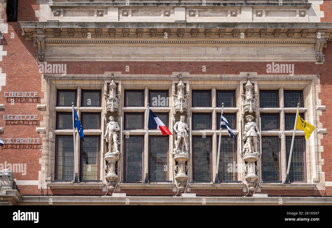 Europa, Francia, Dunkerque - 9 luglio 2022: Primo piano di 3 statue sul lato destro del municipio storico sulla facciata, con alcune bandiere nazionali. Foto Stock