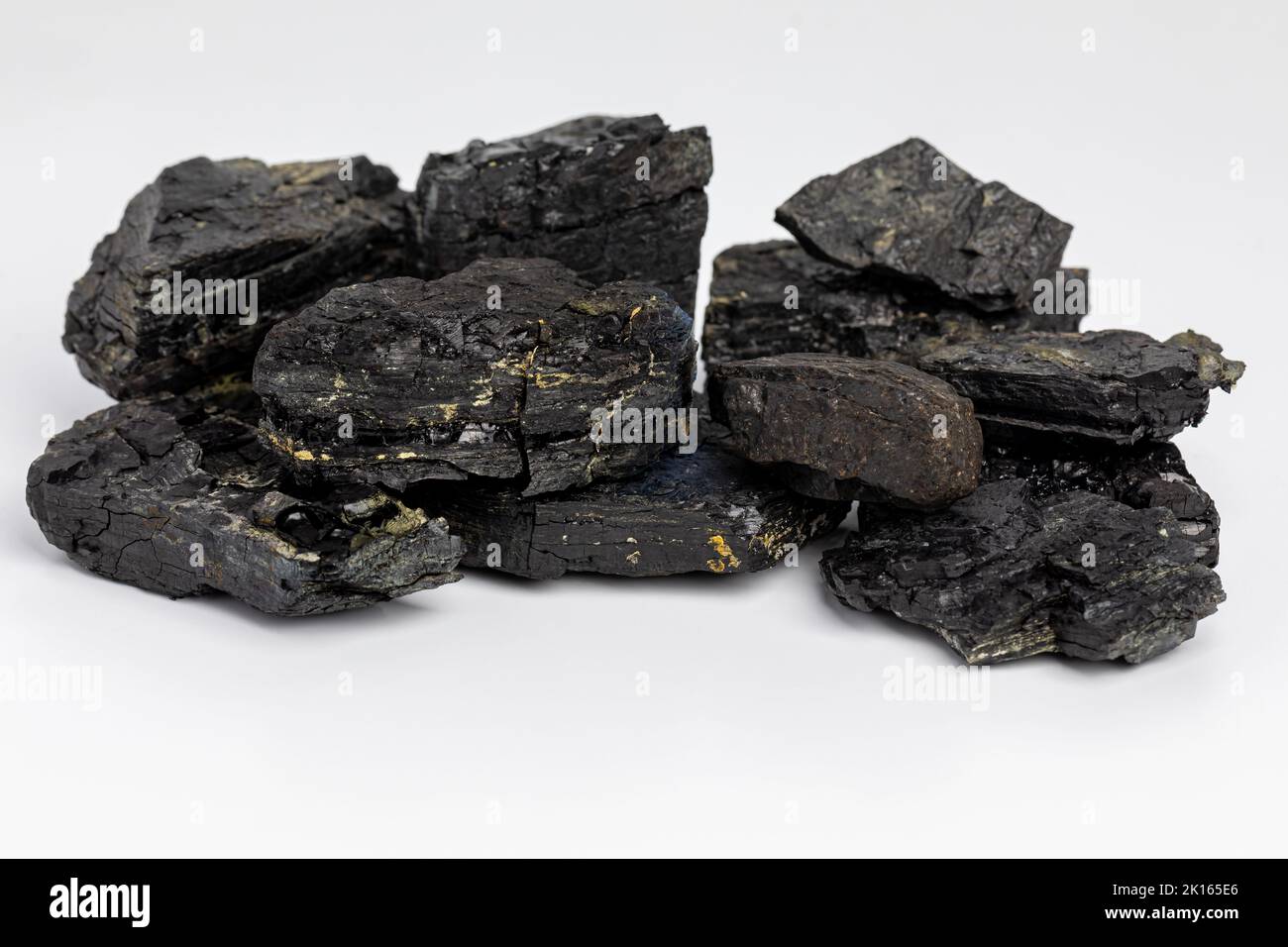 Grumi di carbone nero isolati su sfondo bianco. Concetto di combustibili fossili, inquinamento atmosferico e industria carboniera. Foto Stock