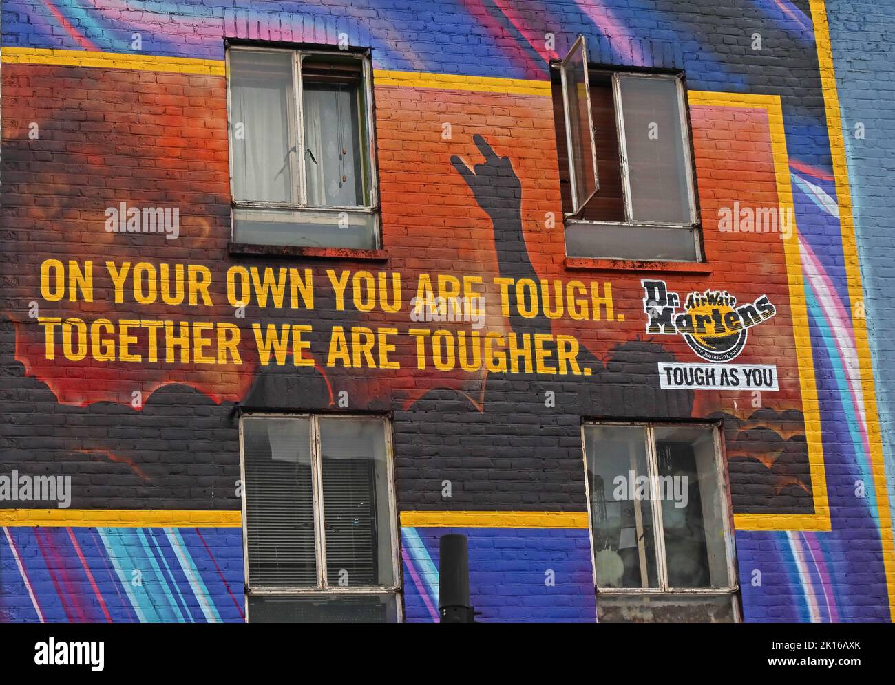 Da soli sei duro, insieme siamo più duri. Dr Martens costruzione murale arte, su un negozio a Camden High Street, Camden Town, Londra, Inghilterra, UK, NW1 Foto Stock
