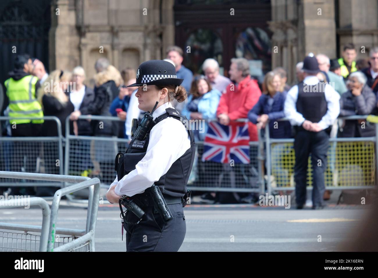 Gli agenti di polizia allineano Whitehall come il pubblico in attesa che la processione della Regina della bara per raggiungerli. Foto Stock