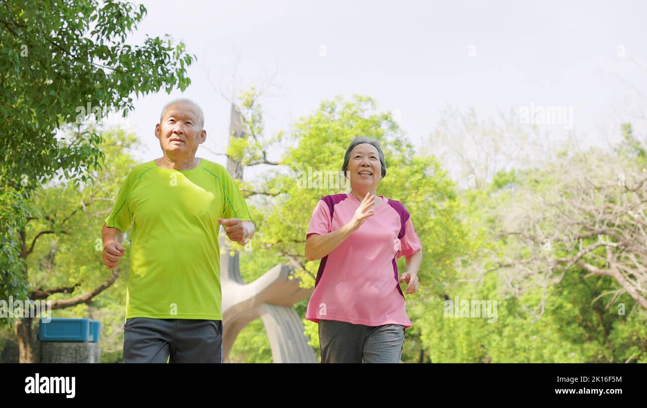 felice coppia asiatica anziana allenarsi e correre nel parco Foto Stock