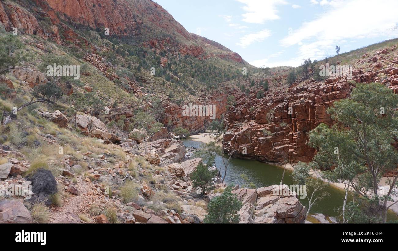 Splendida vista sulla gola rossa e l'acqua di sorgente dalla gola di Ormiston nella catena montuosa West Macdonnell nel Red Centre, Australia. Foto Stock